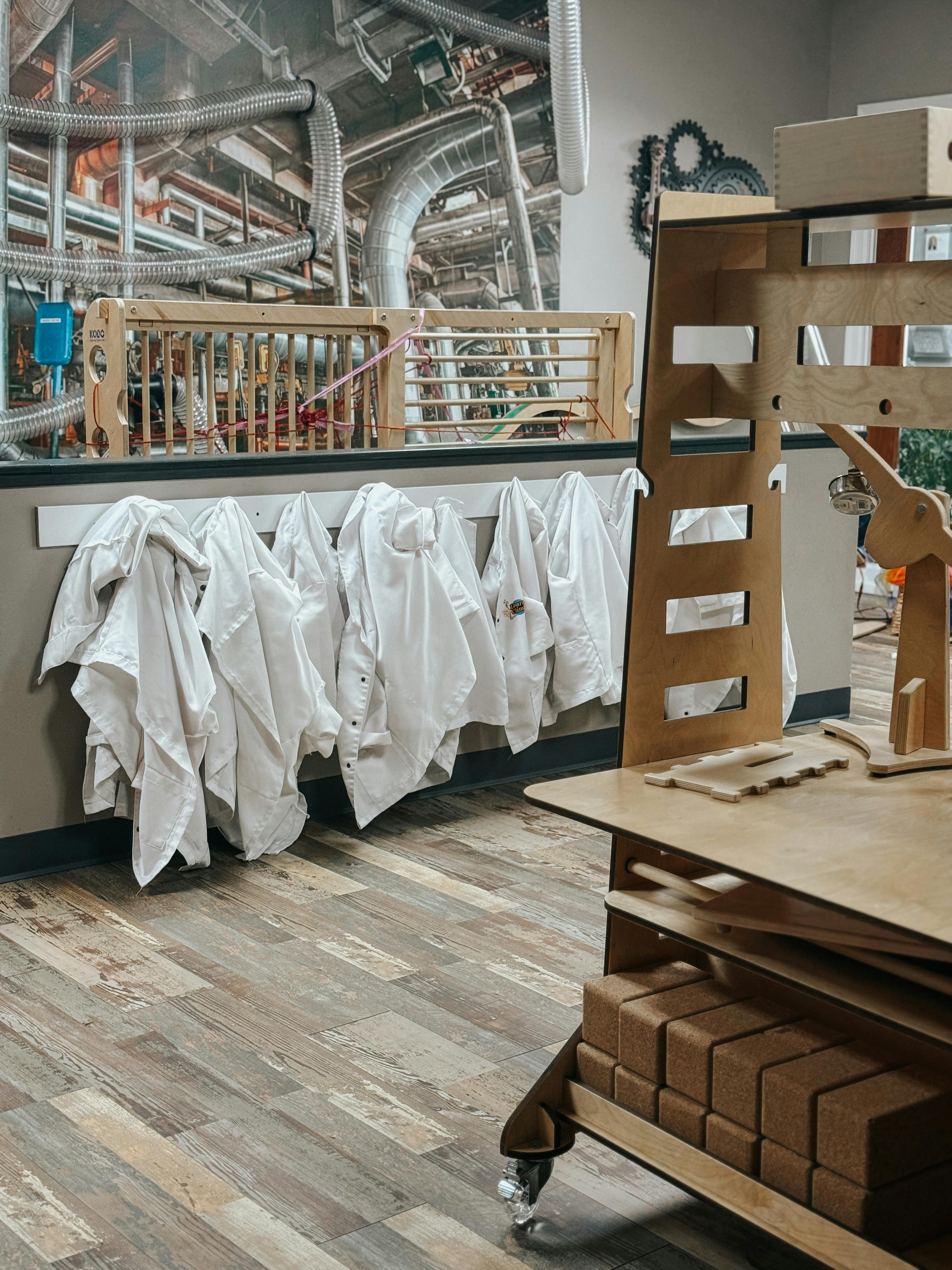 White lab coats hanging on a rack in a classroom