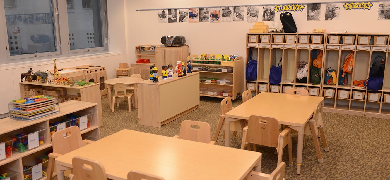 Classroom with small tables and chairs, storage shelves, and cubbies