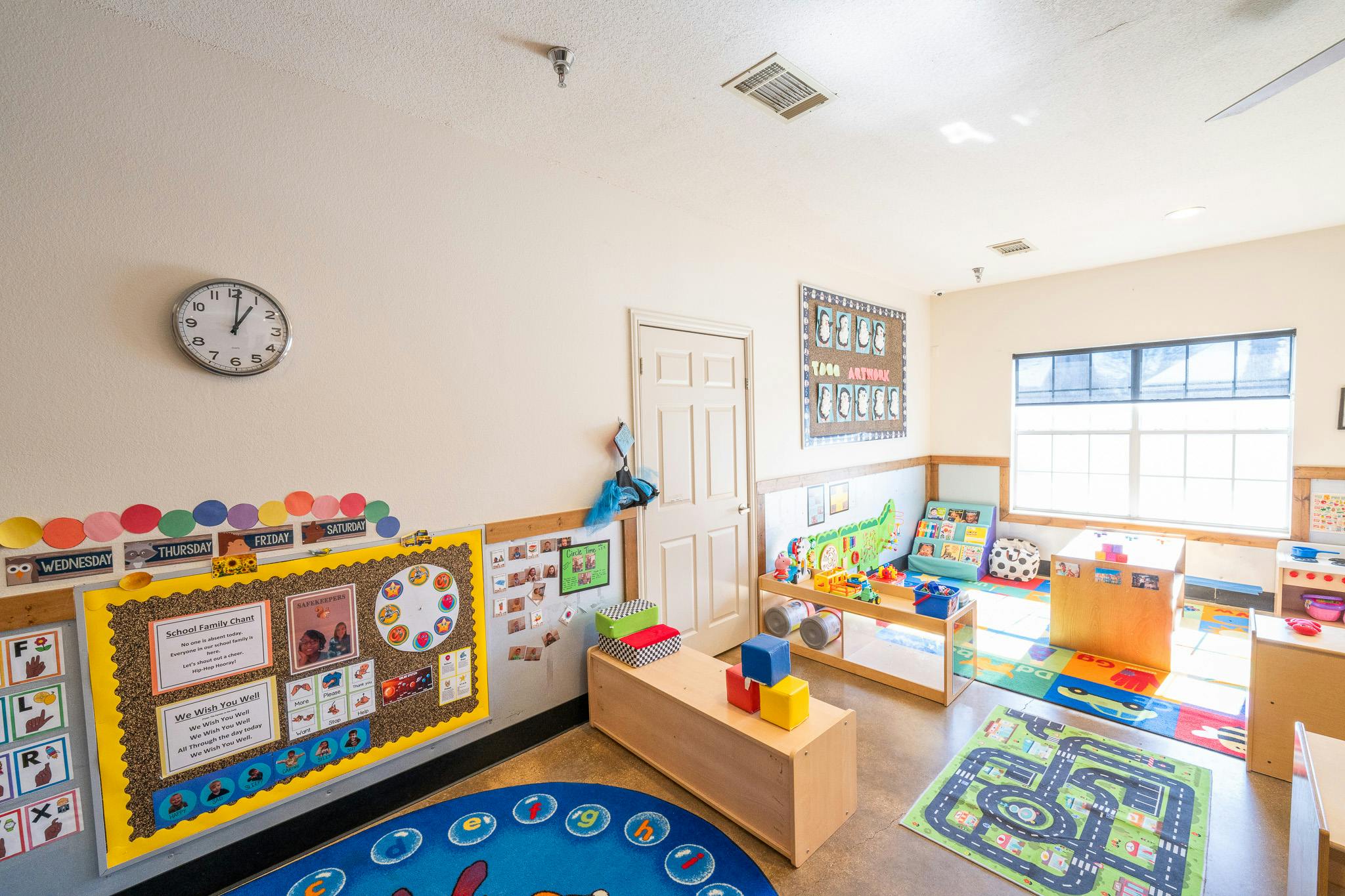 Classroom interior with play rugs and educational wall displays