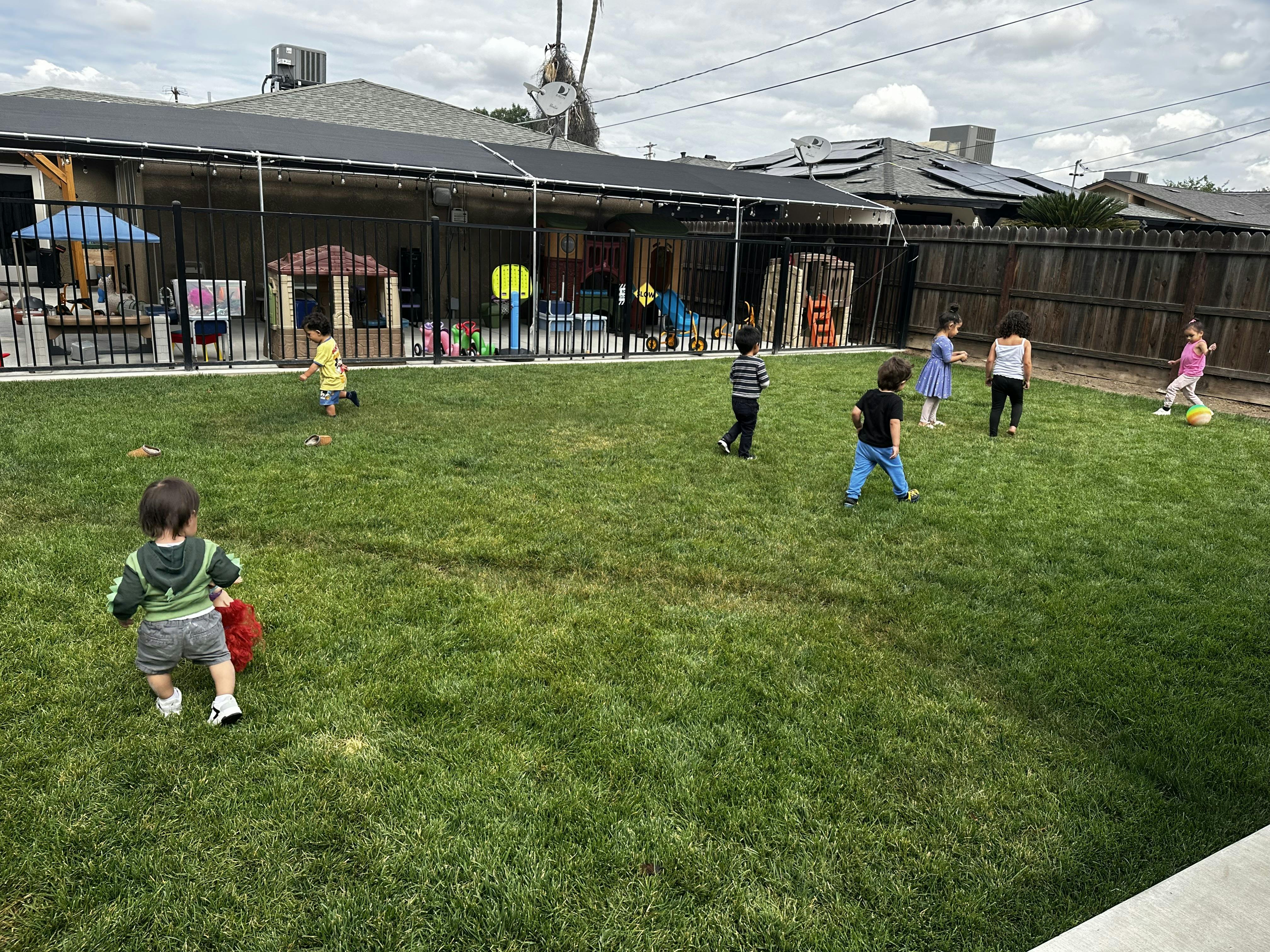 multiple children playing in a grassy backyard