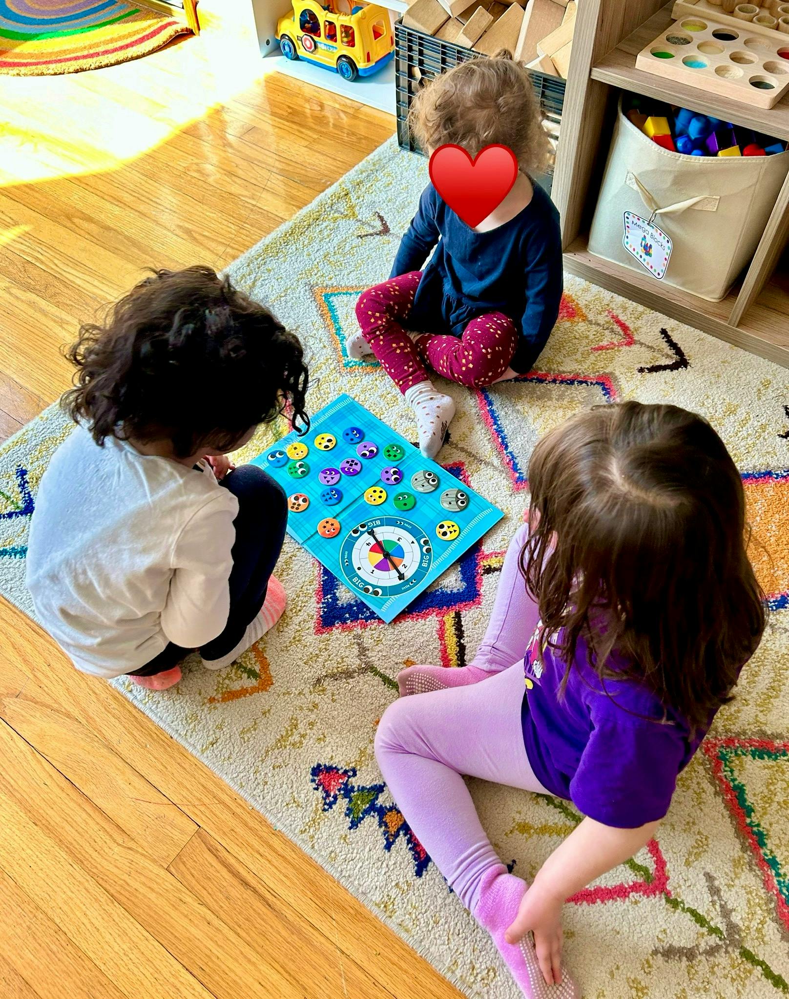 Three children playing a board game on a rug