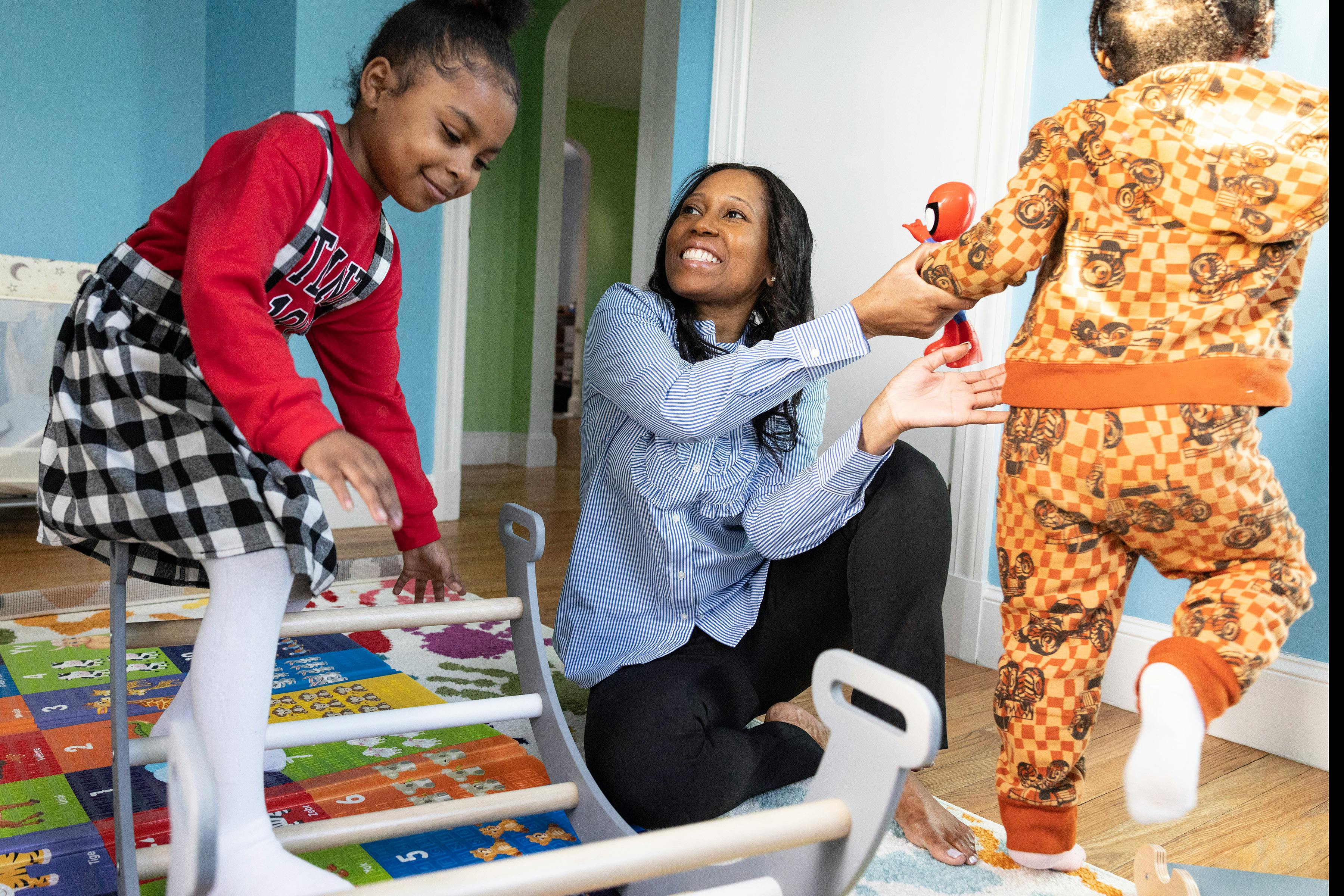 Adult and two children playing with a climbing toy
