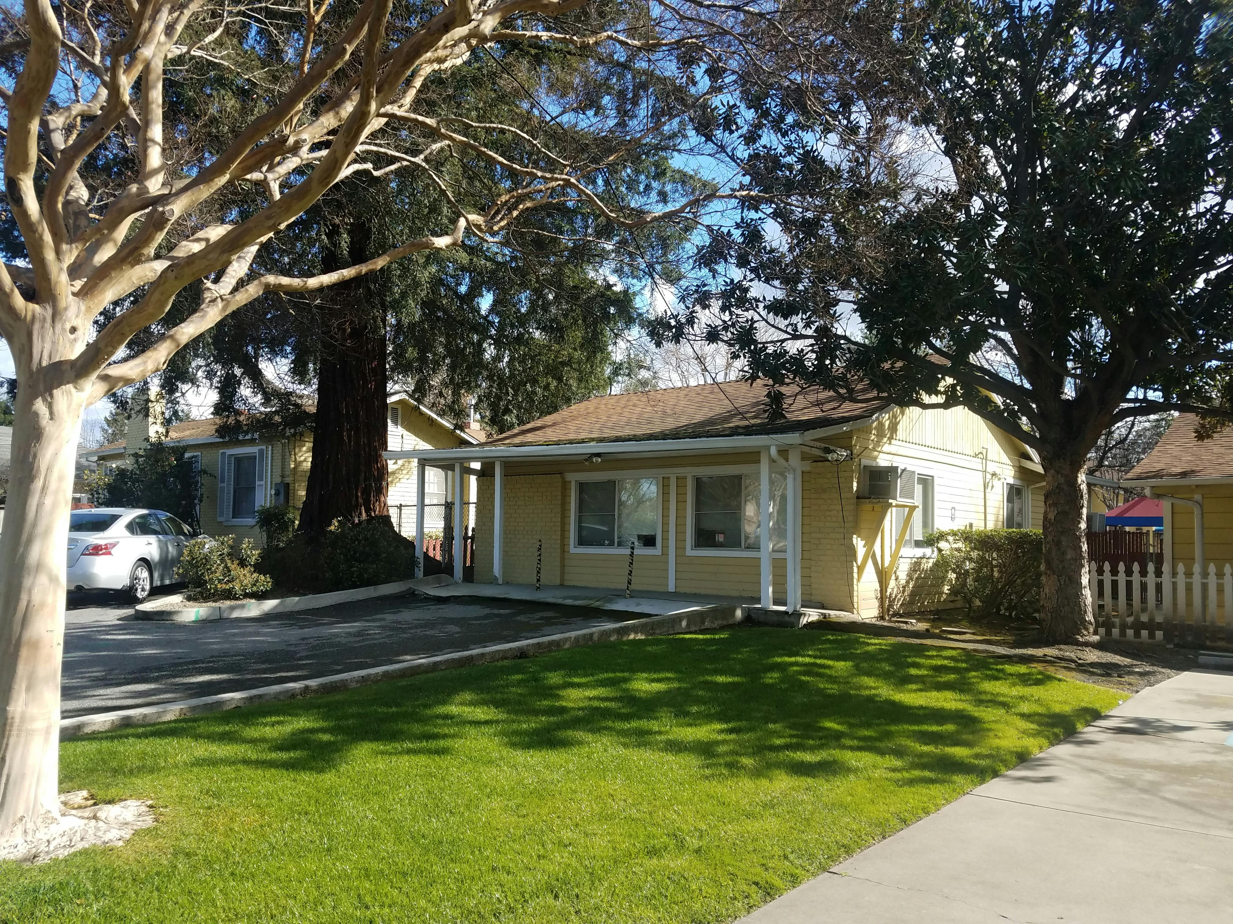 Yellow house with a porch and green lawn