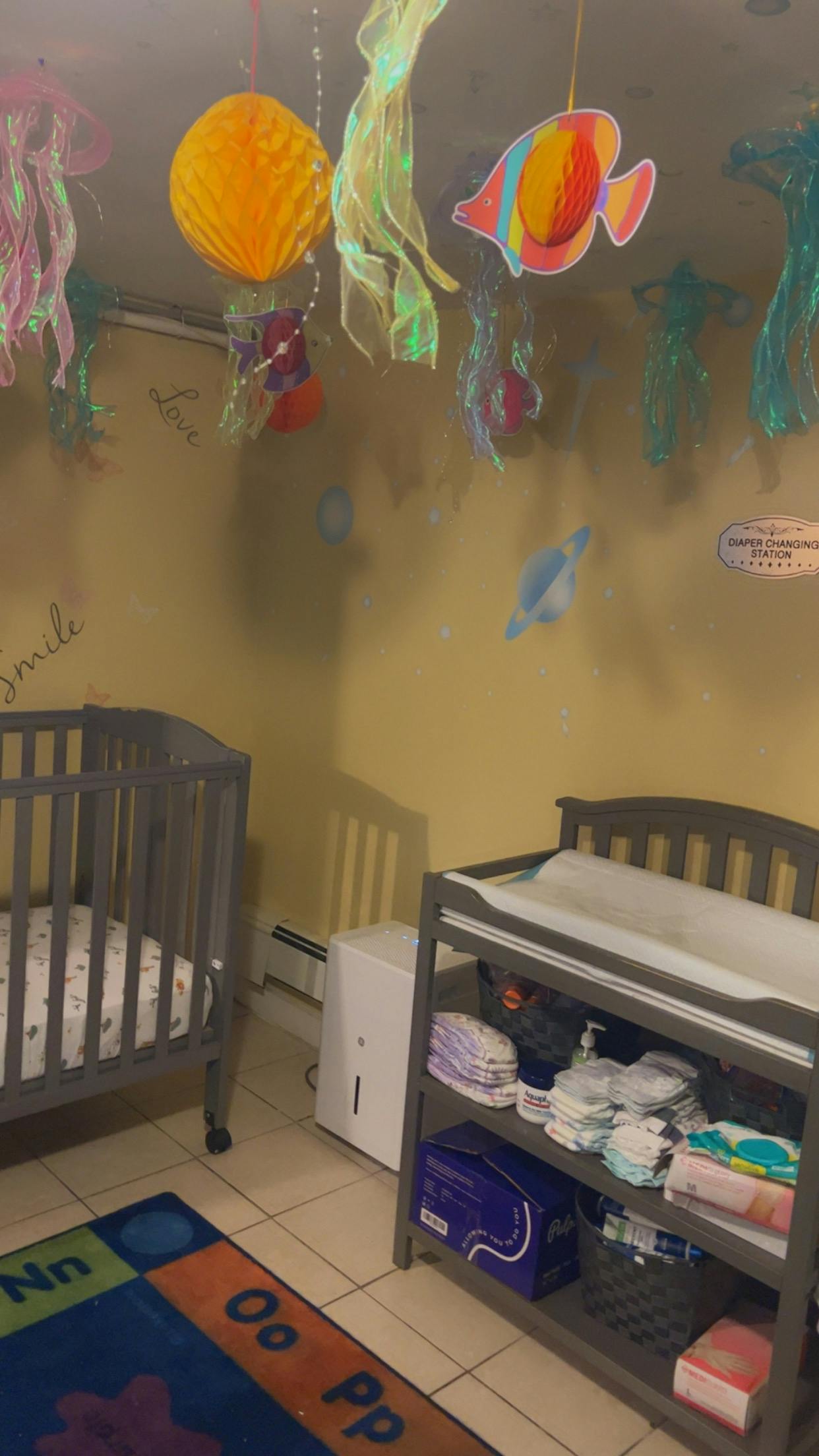 Nursery room with a crib, changing table, and hanging decorations