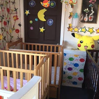 Two cribs in a room with decorations