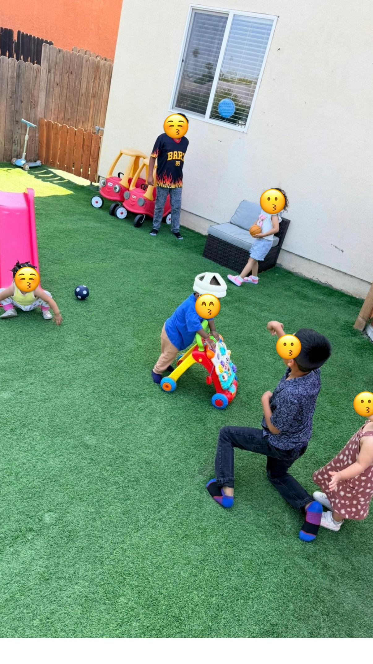 Group of children playing with toys in an outdoor yard