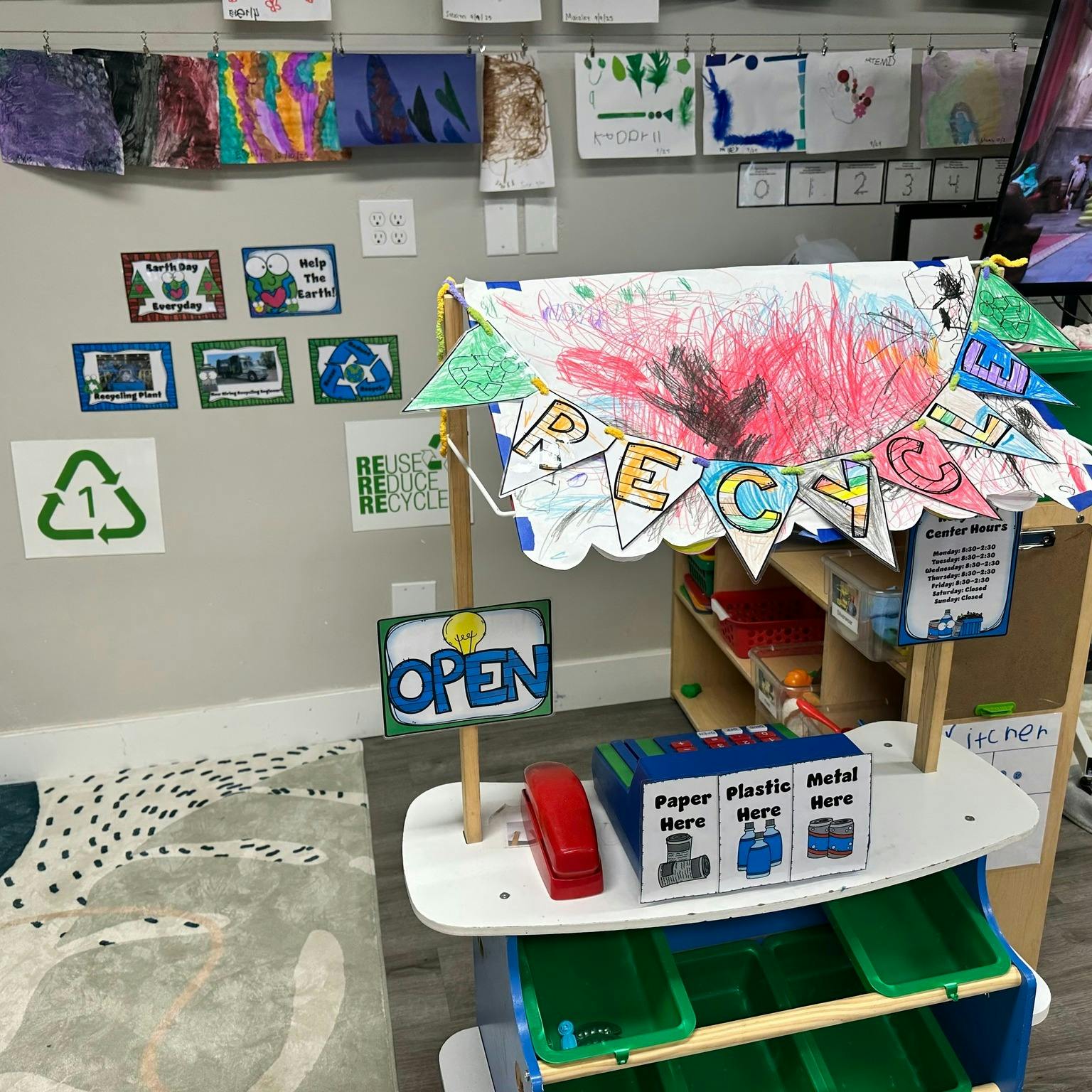 Children's play recycling center with an "OPEN" sign