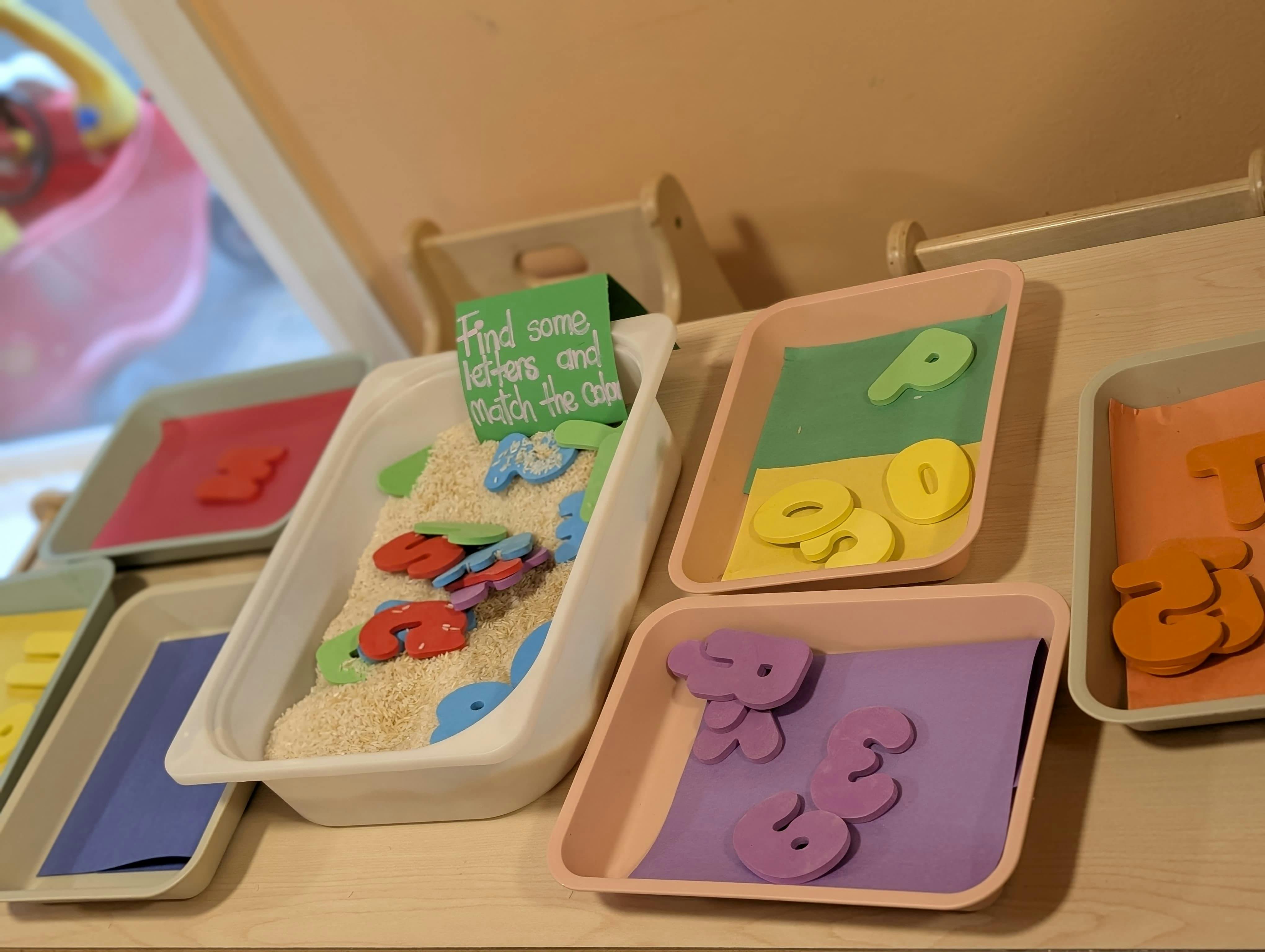 Trays with rice, letters, and numbers for a color-matching activity