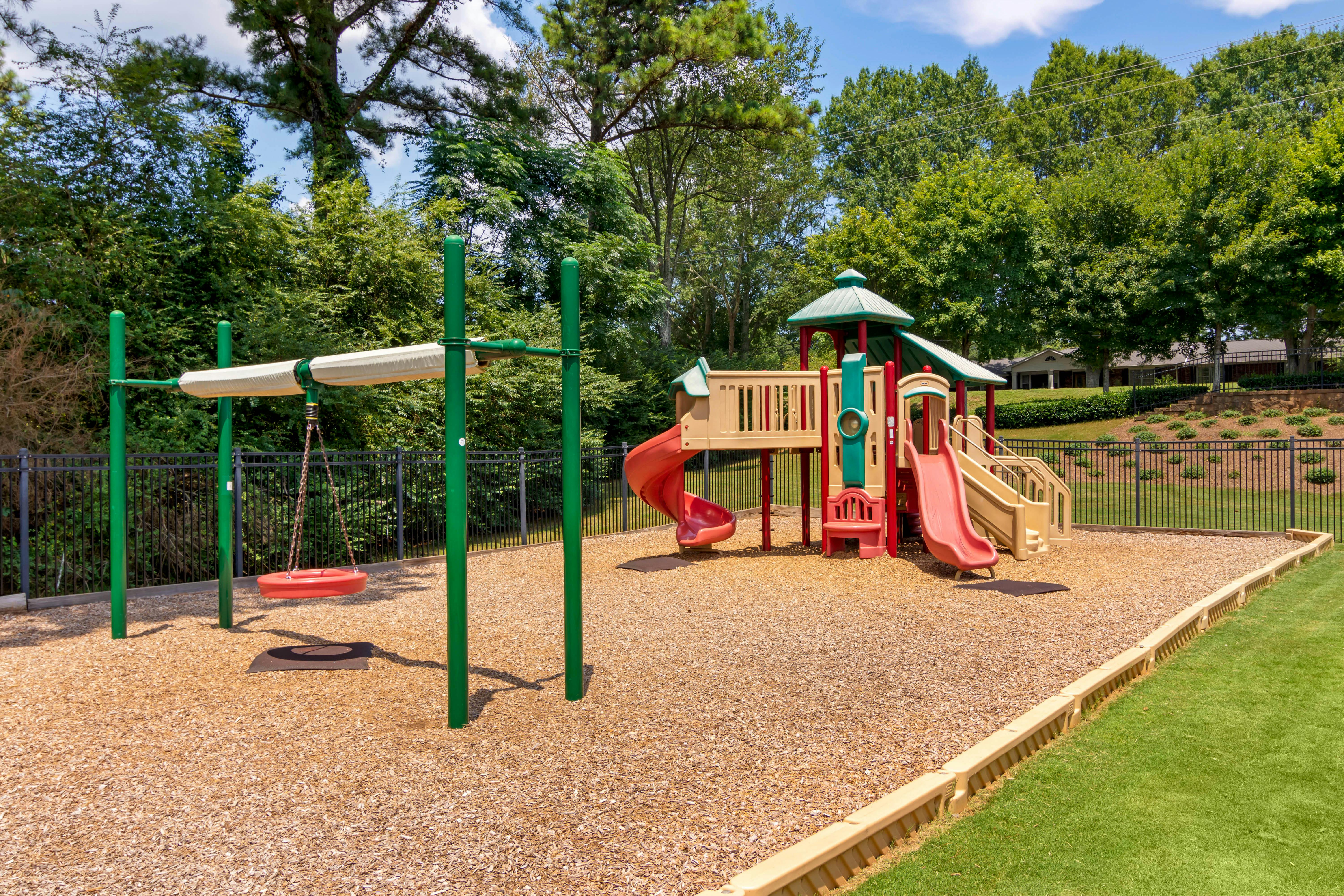 Playground with swings, slides, and climbing structures on wood chips