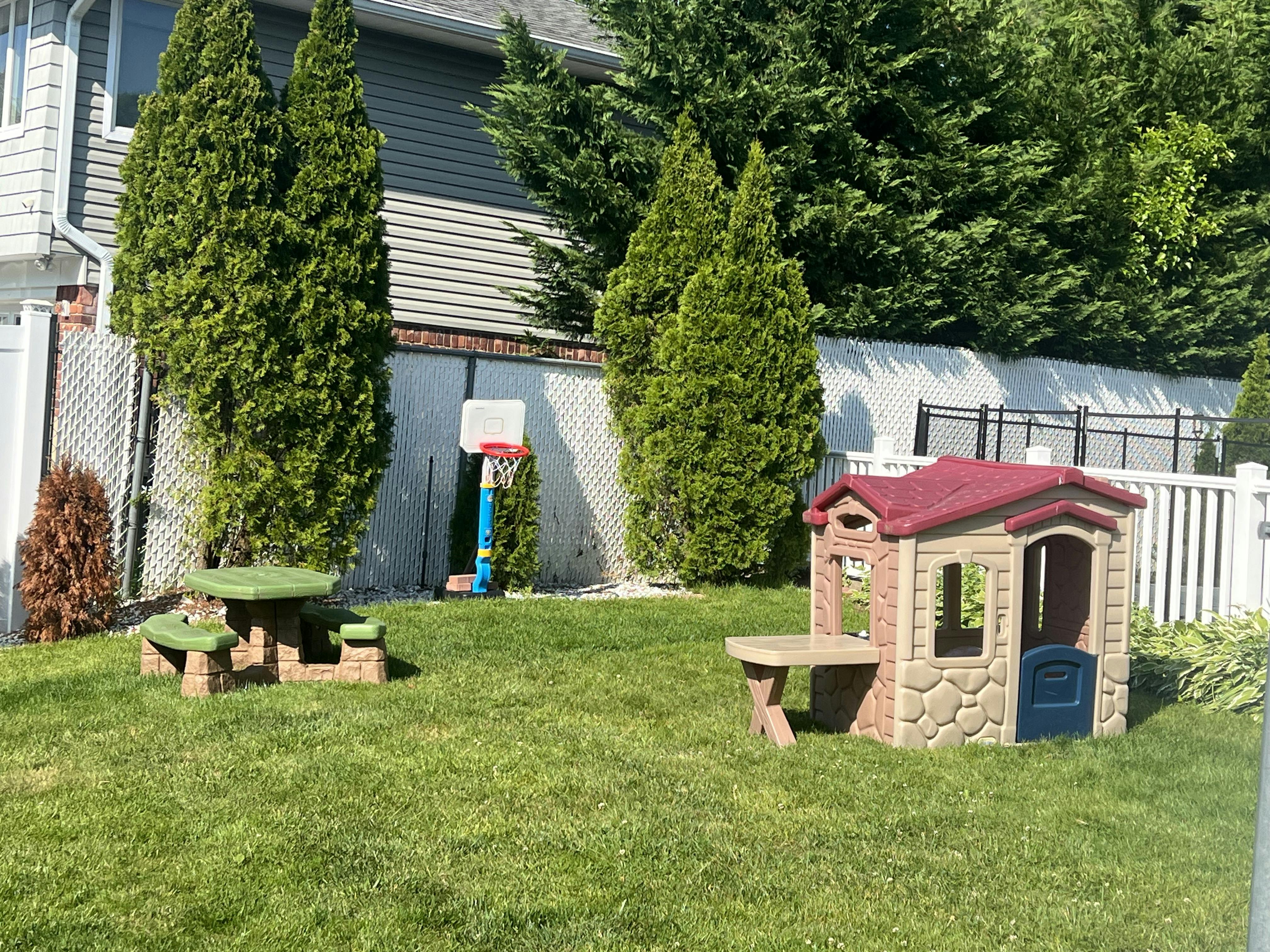 Playhouse and picnic table in a grassy backyard