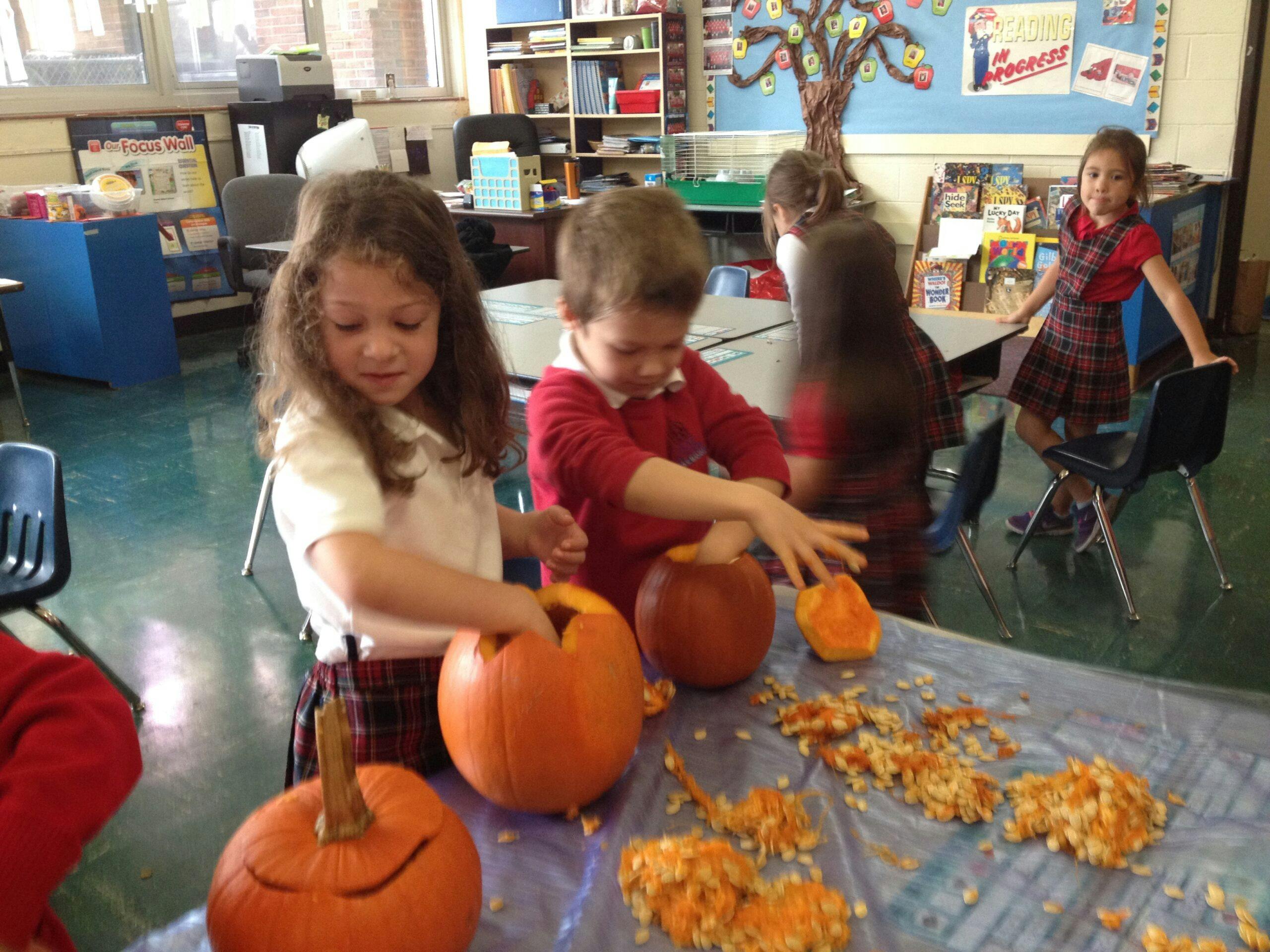 Children carving pumpkins in a classroom