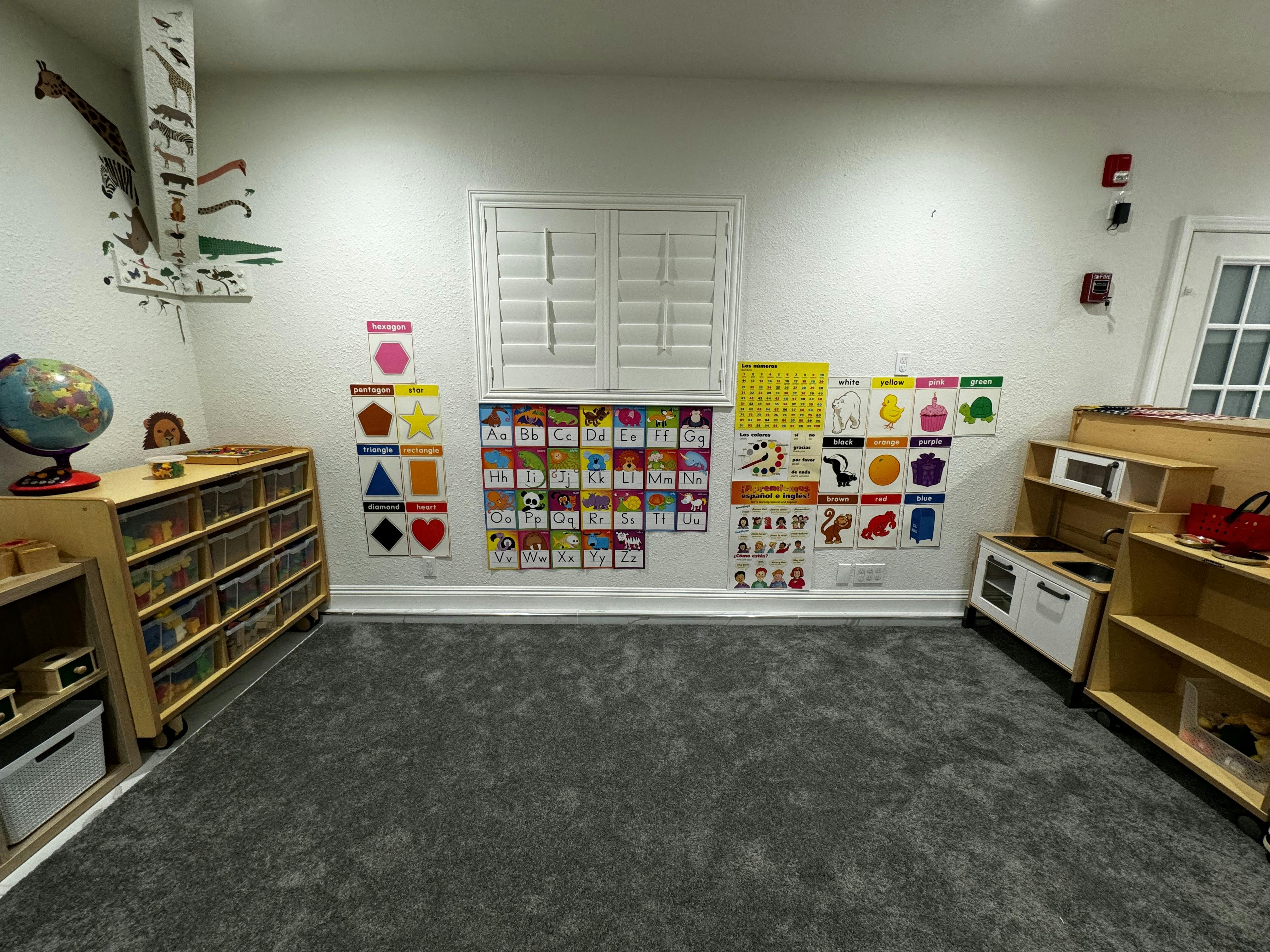 Children's play area with educational charts and toy kitchen set