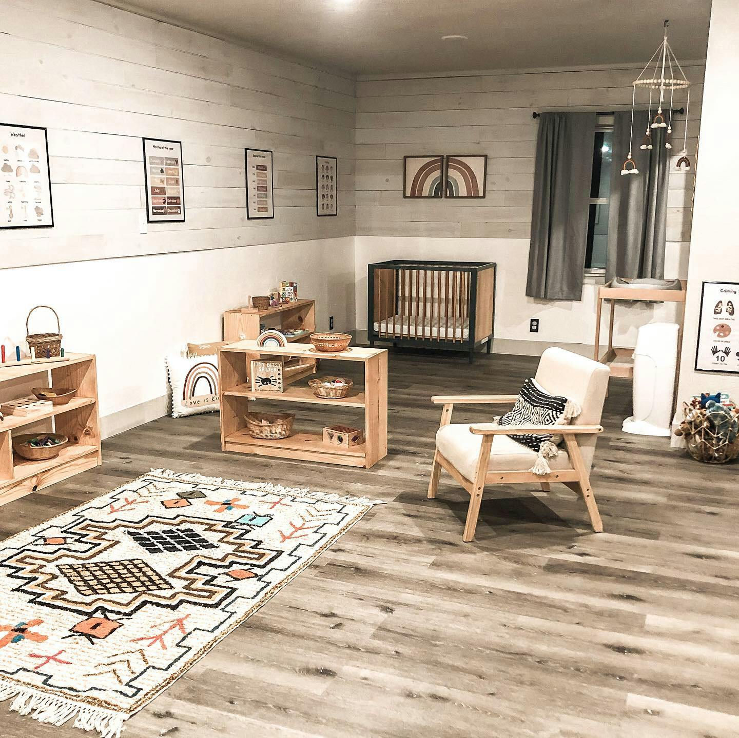 Nursery room with crib, wooden shelves, and armchair