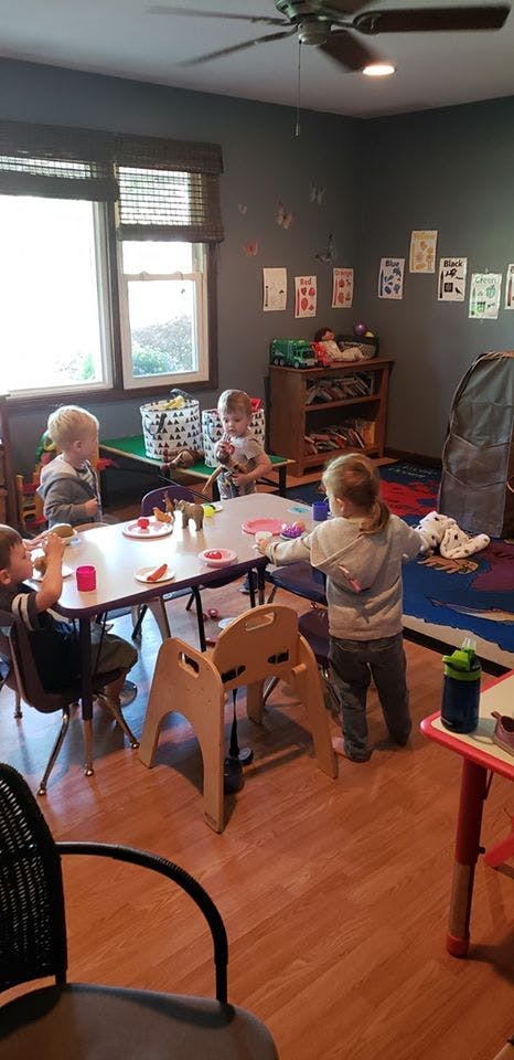 Children at a table in a room with windows and wall decorations