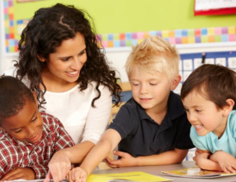 Person and two children looking at a book