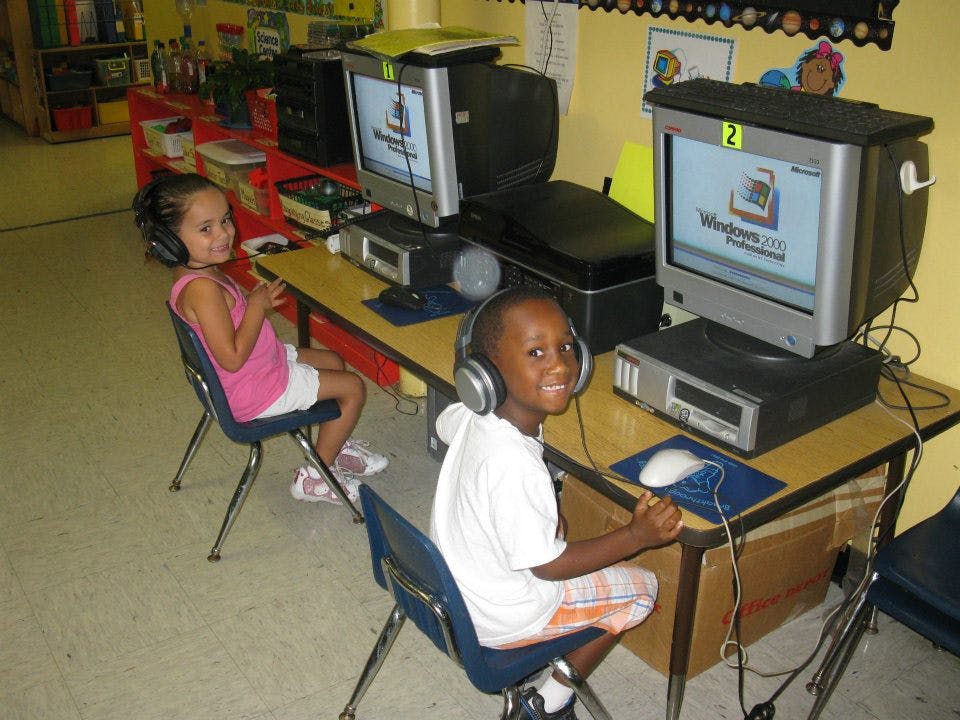 Two children wearing headphones at computers