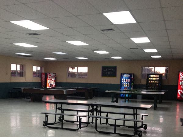 Empty room with picnic tables, vending machines, and a pool table