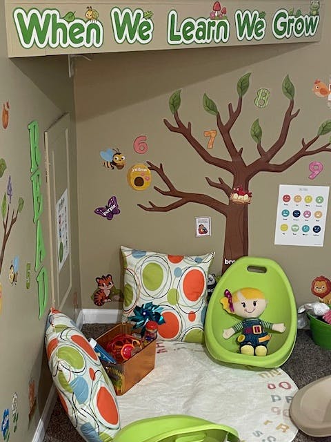 Children's play area with wall decals and a sign that reads "When We Learn We Grow"