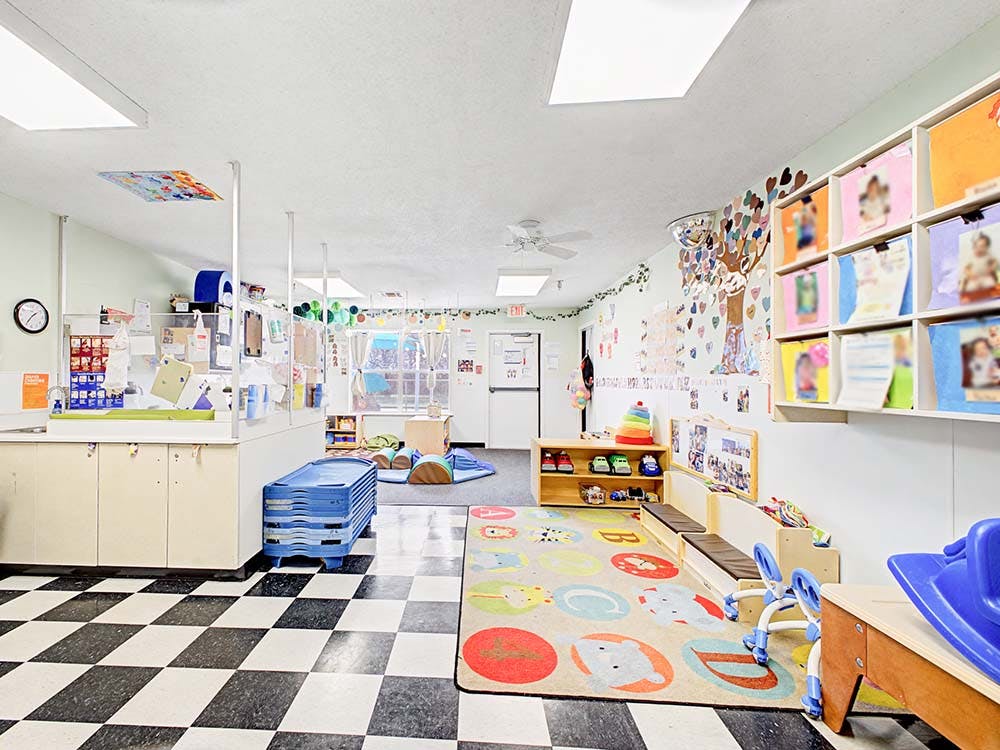 A colorful empty classroom with toys, storage, and a checkered floor