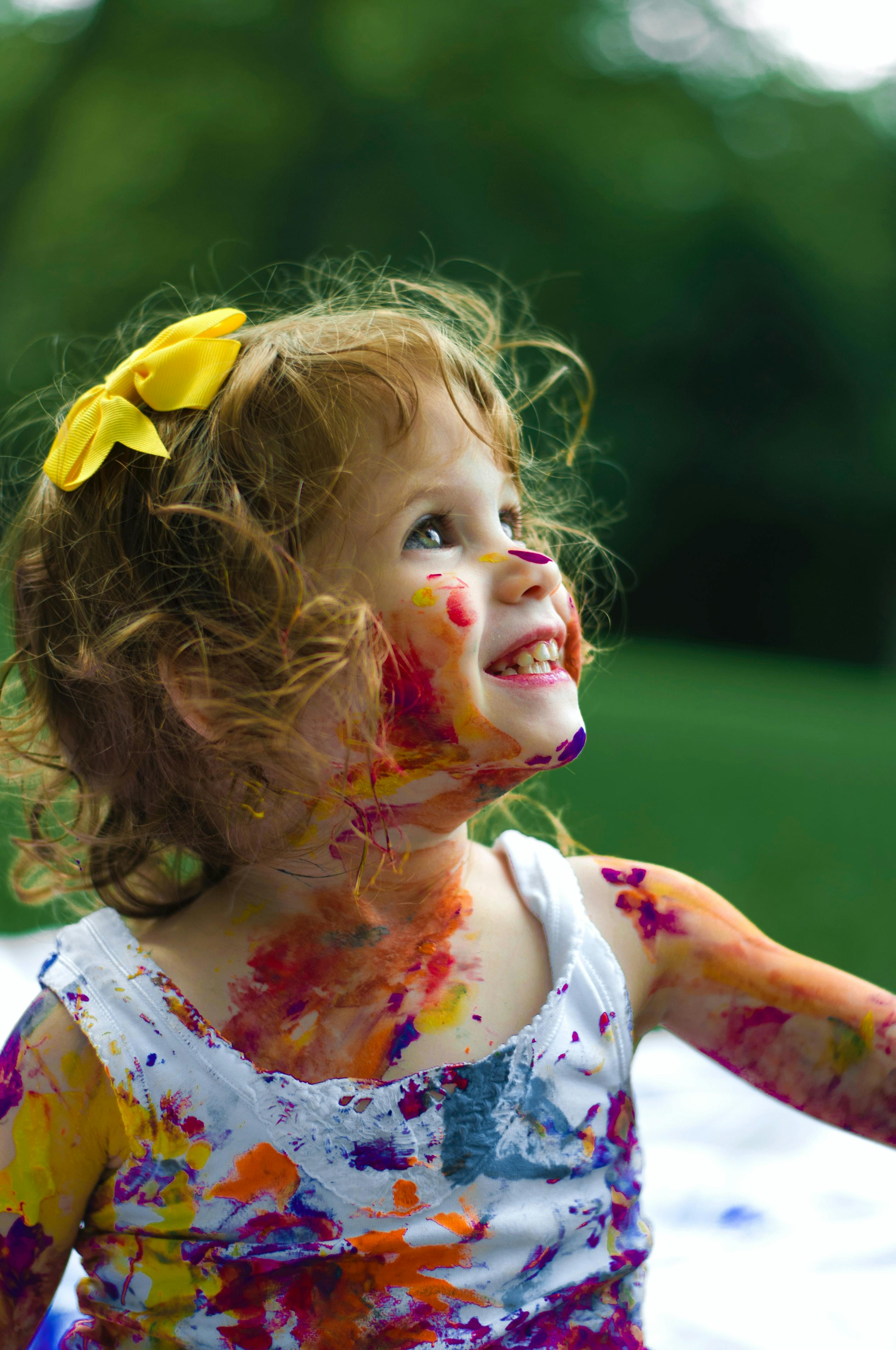 Child with paint on face and clothes