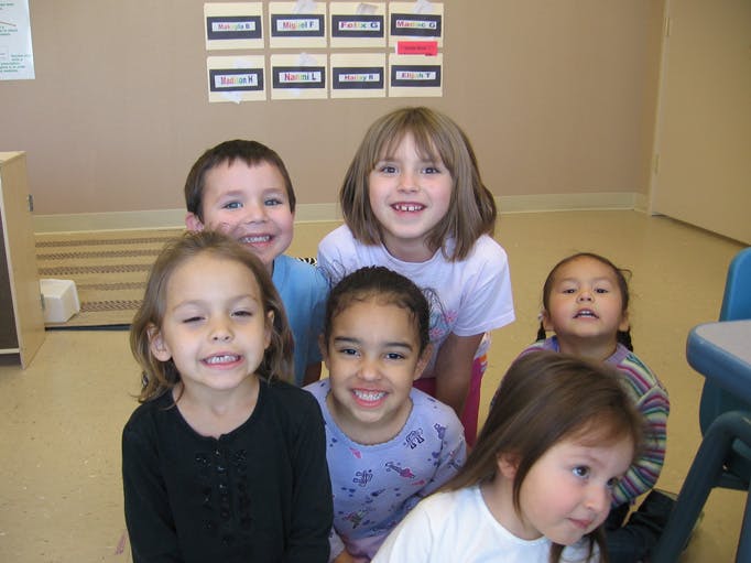 Group of children smiling in a classroom