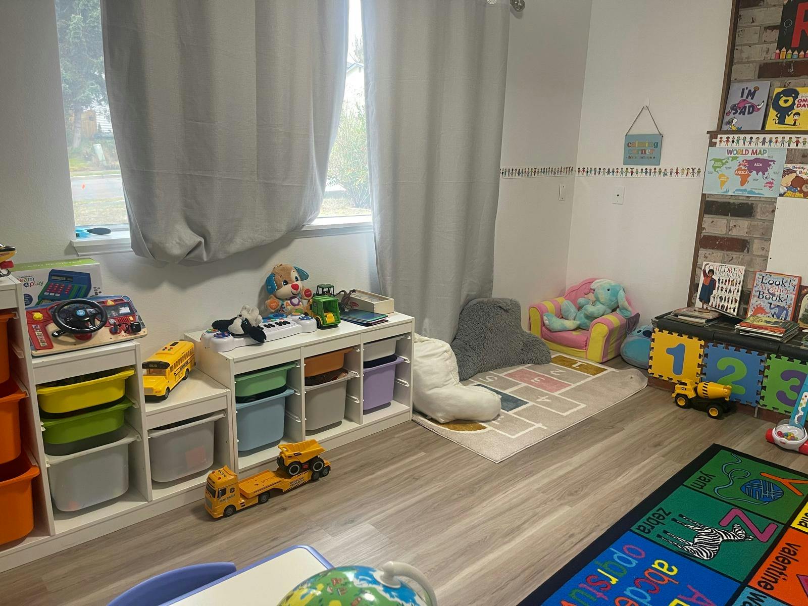 Children's playroom with toys, a hopscotch rug, and reading corner