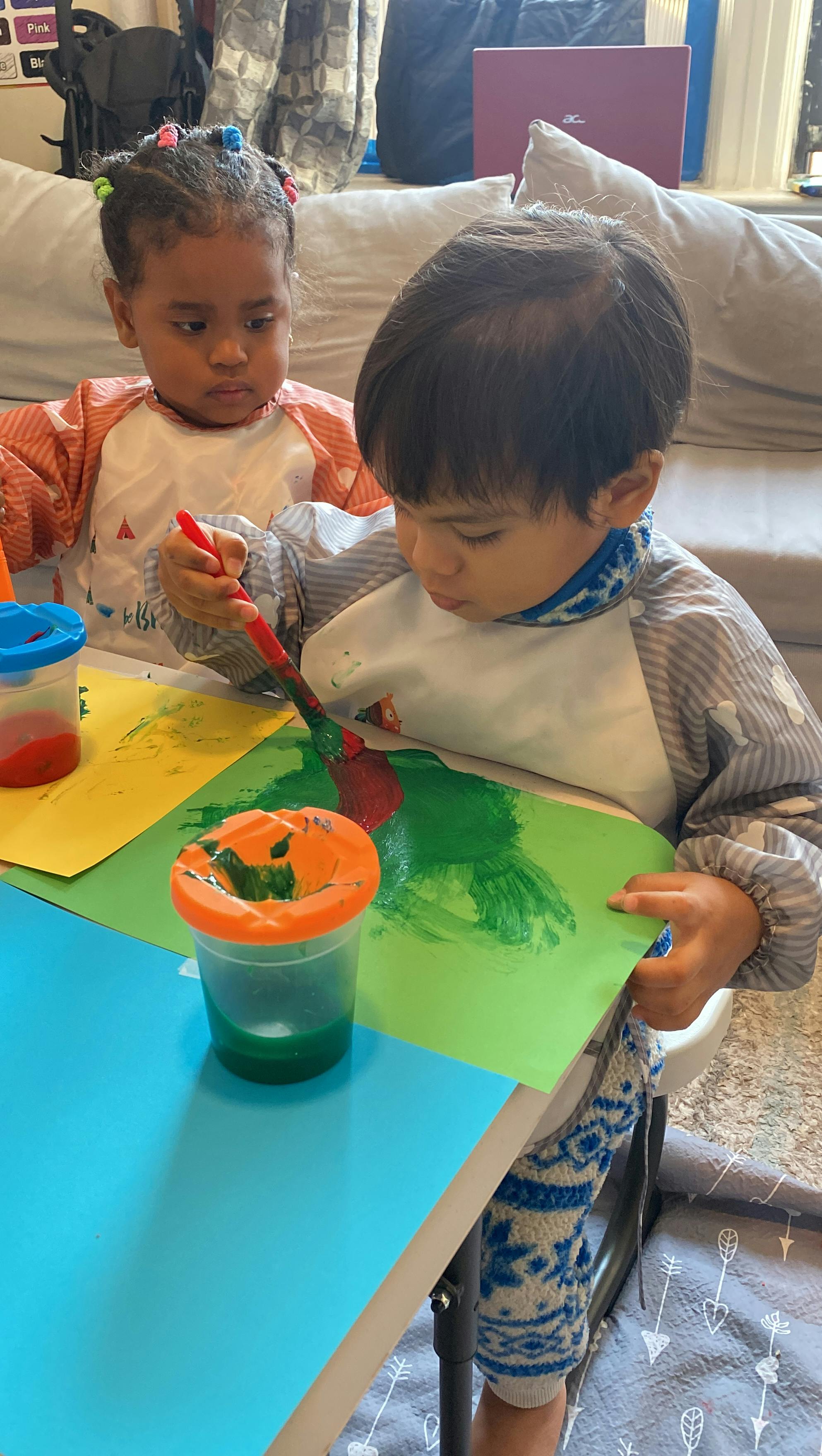 Two children painting at a table