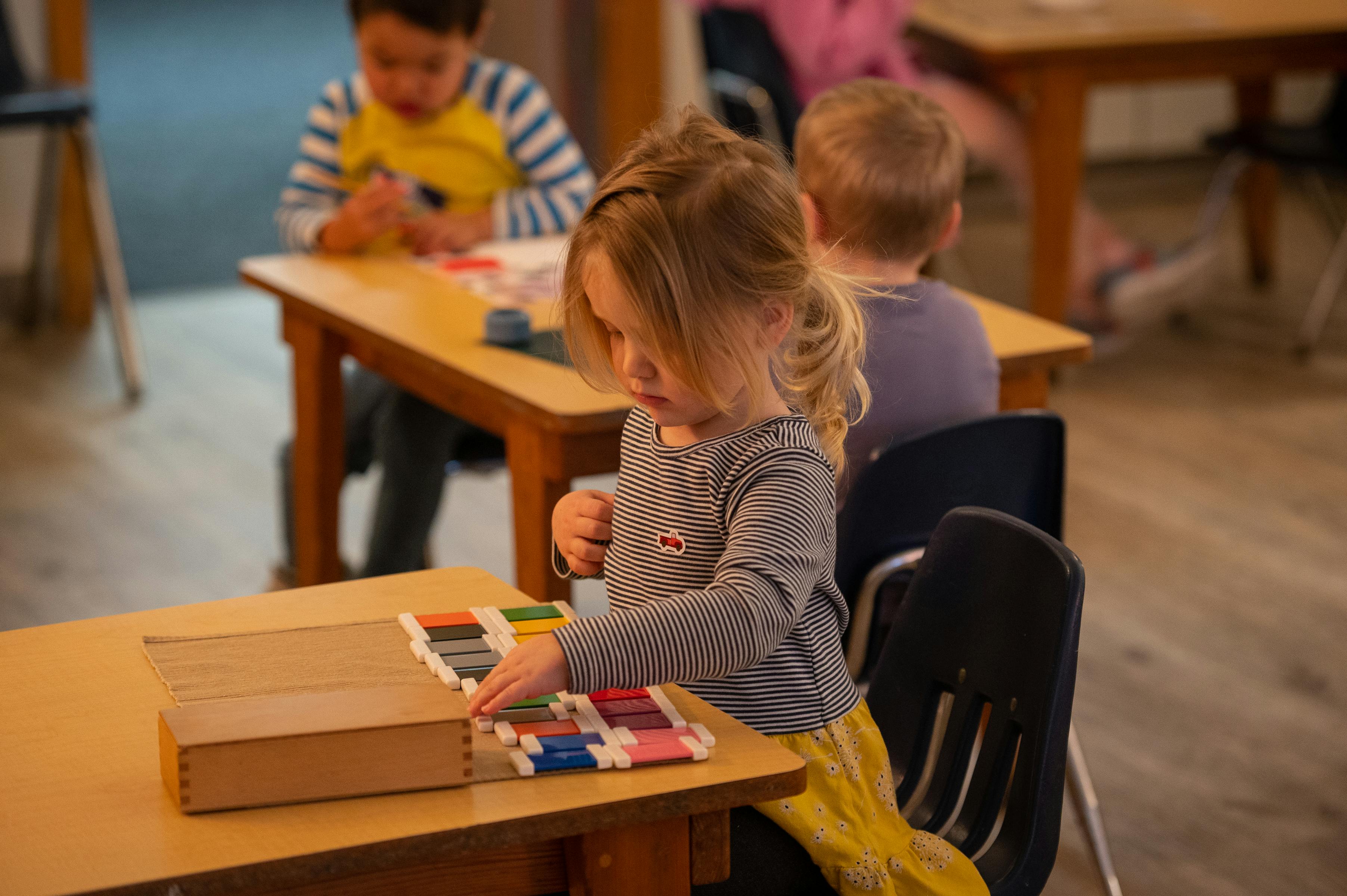 Child at a table playing with colorful blocks