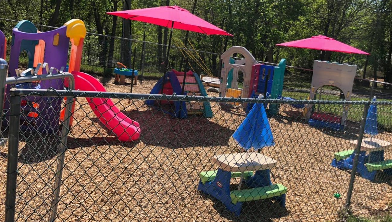Outdoor playground with slides, play structures, and picnic tables