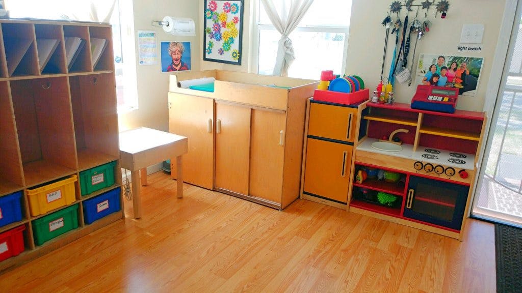 Children's play area with cubbies, changing table, and toy kitchen