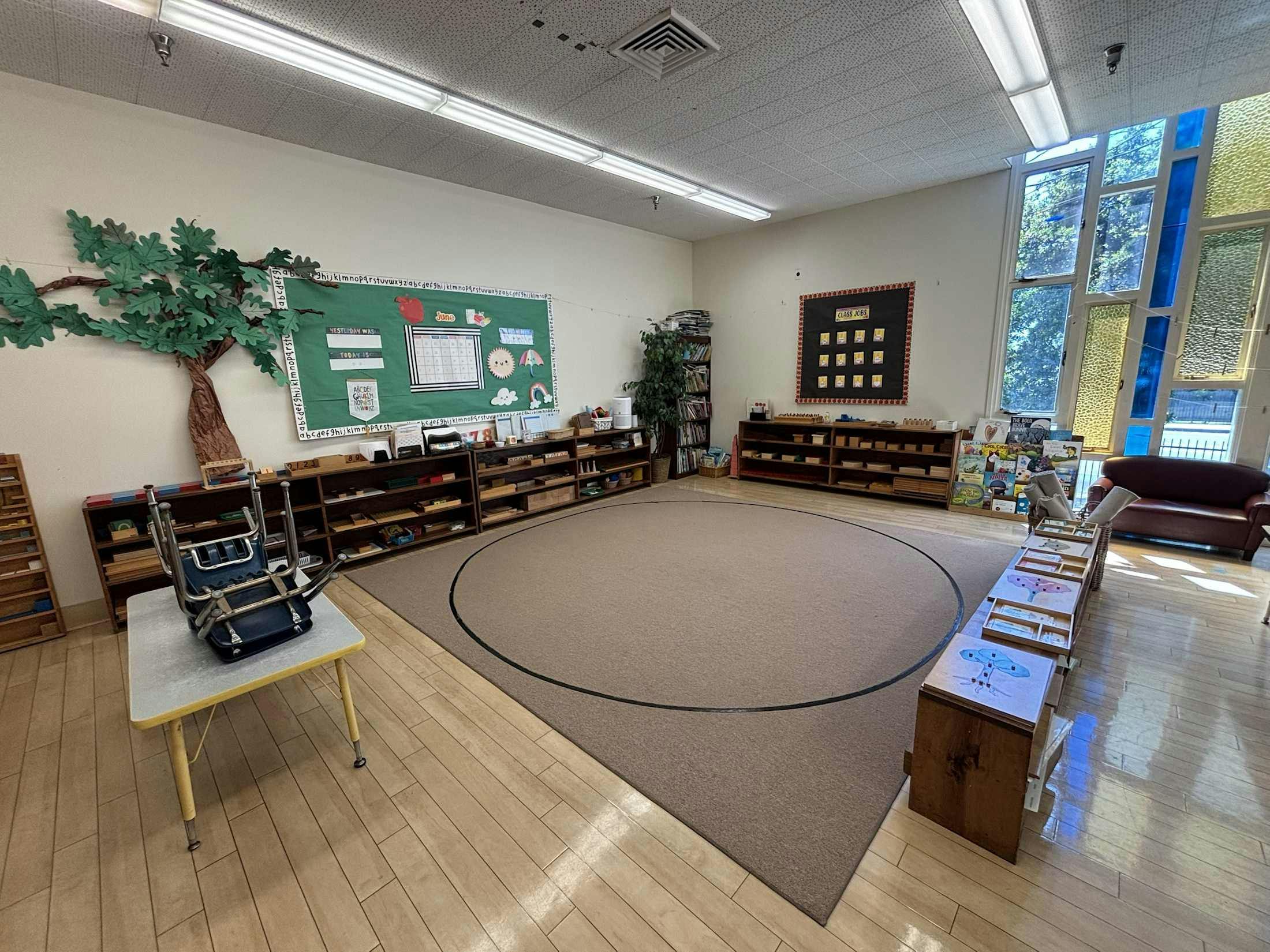 Classroom with shelves, a circular rug, and educational displays