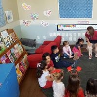 Adults and children sitting on the floor in a classroom