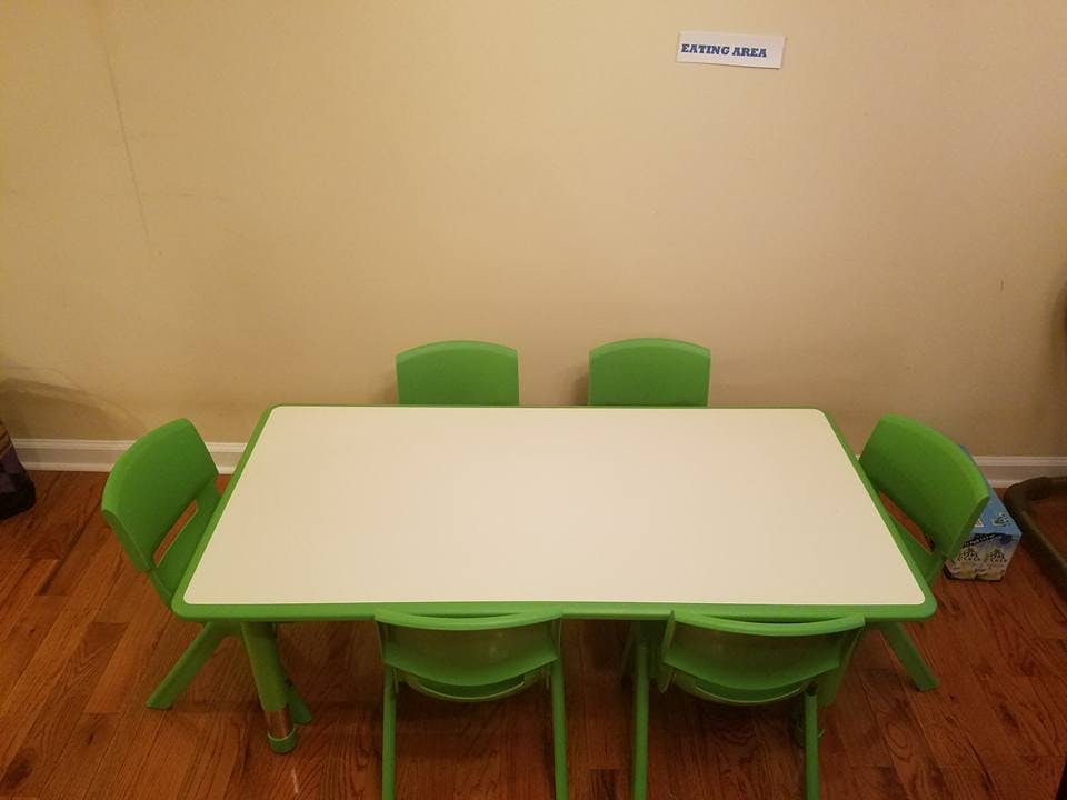 White table with green trim and four green chairs