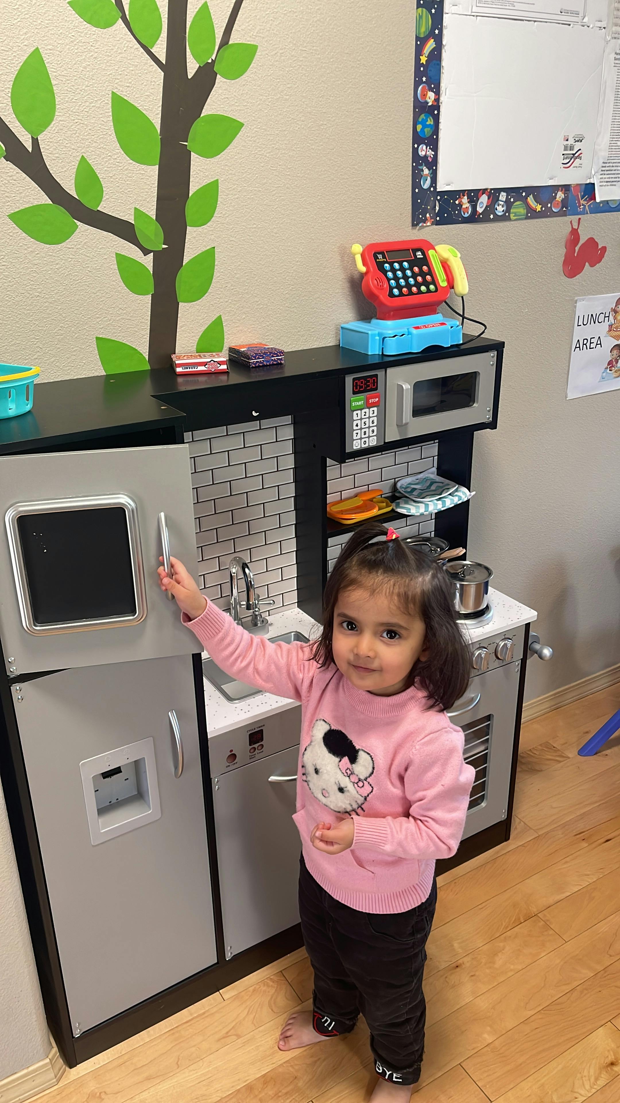 Child playing with a toy kitchen set
