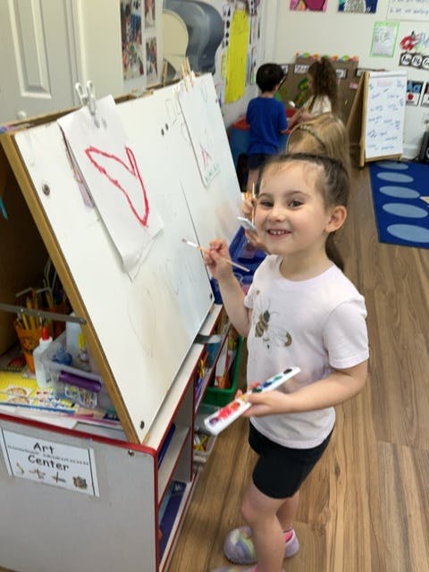 Child painting on an easel in an art center