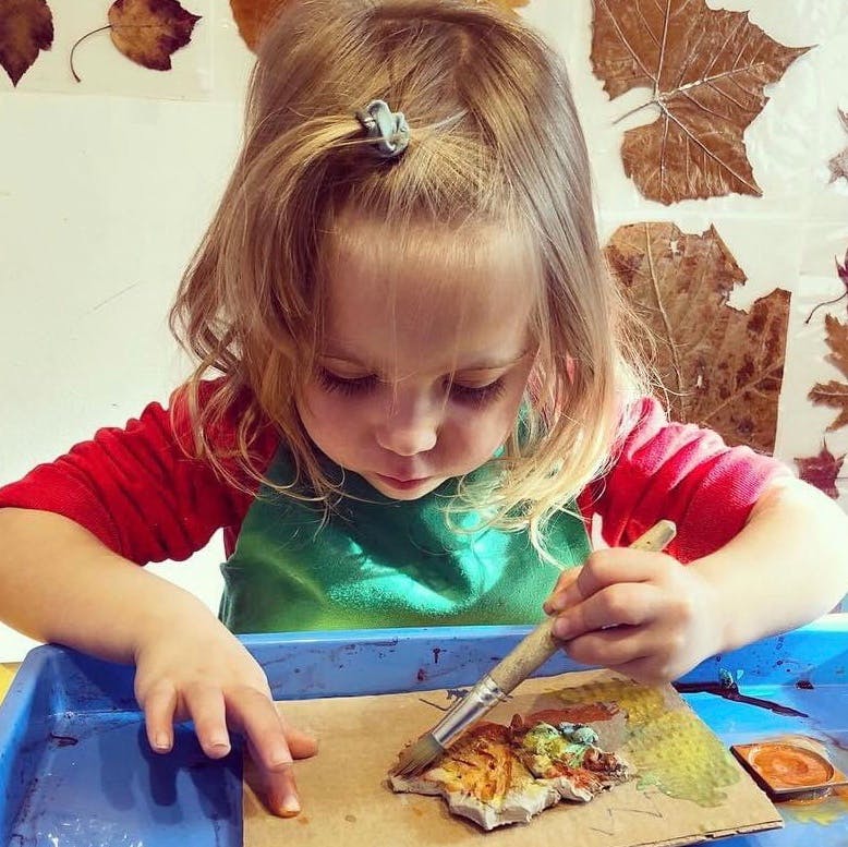 Child painting a leaf