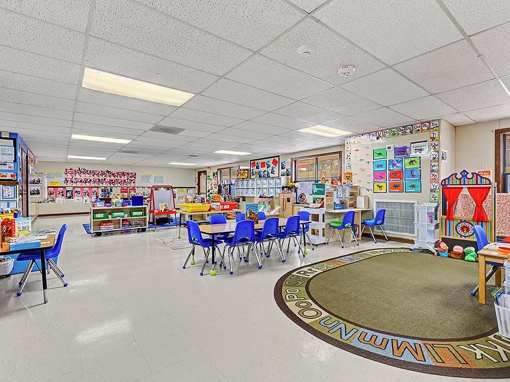 Empty classroom with tables, chairs, and colorful decorations