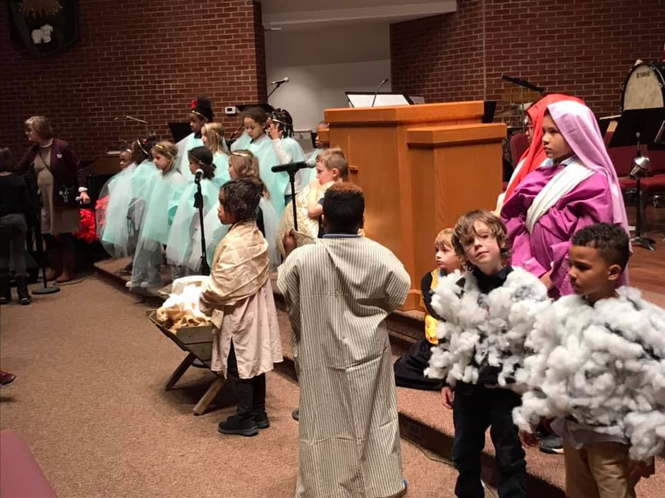 Children in costumes performing a play on a stage