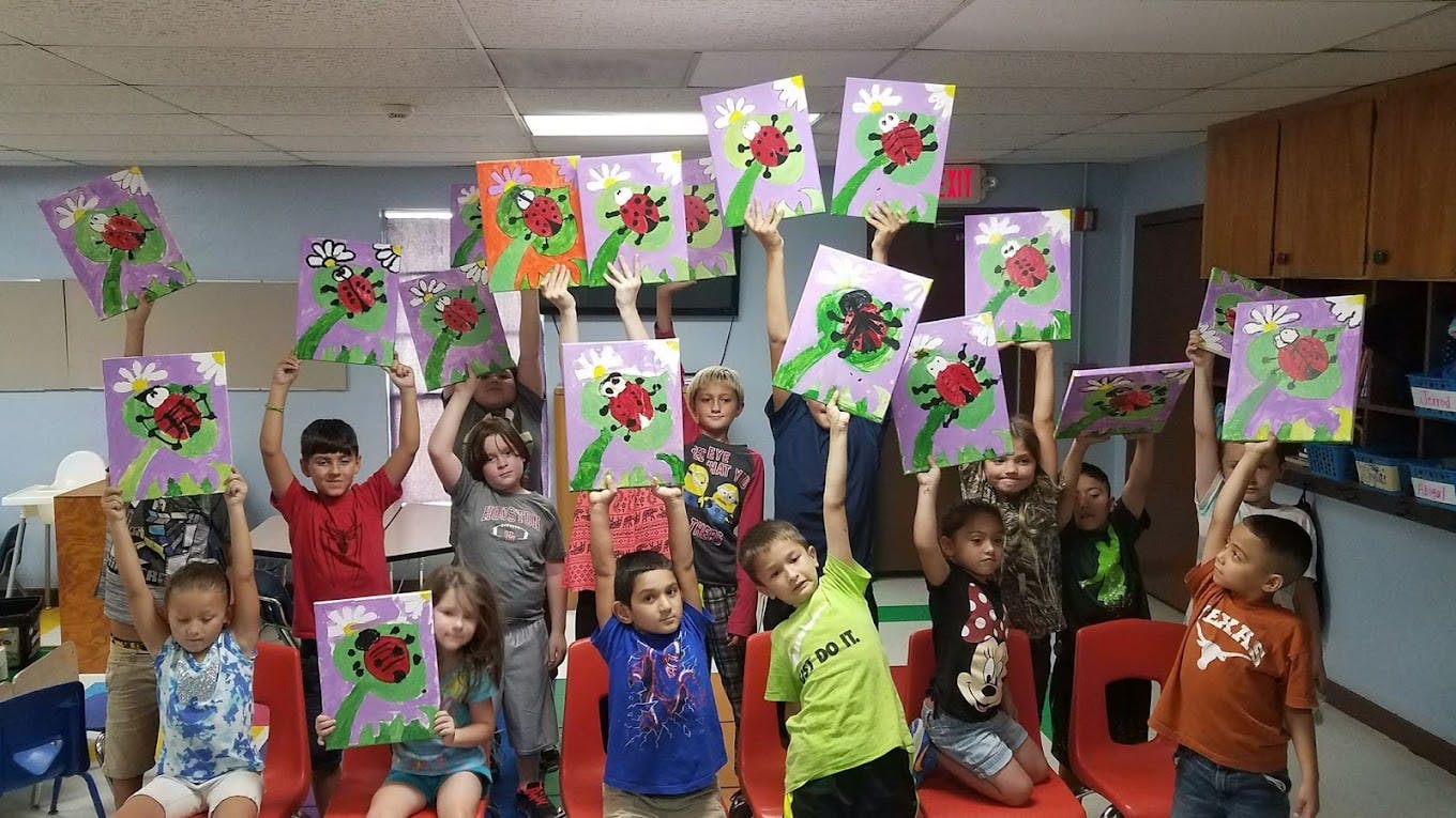Group of children holding up their artwork