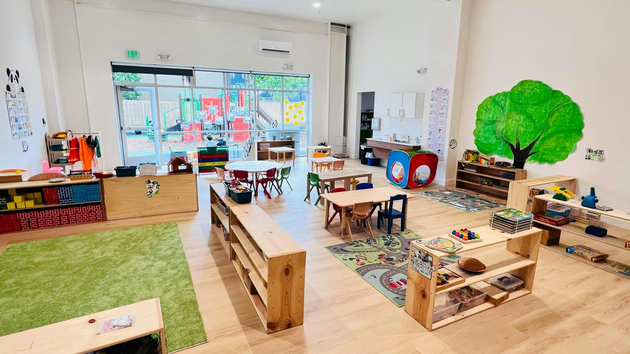 Empty classroom with small tables, chairs, and shelves
