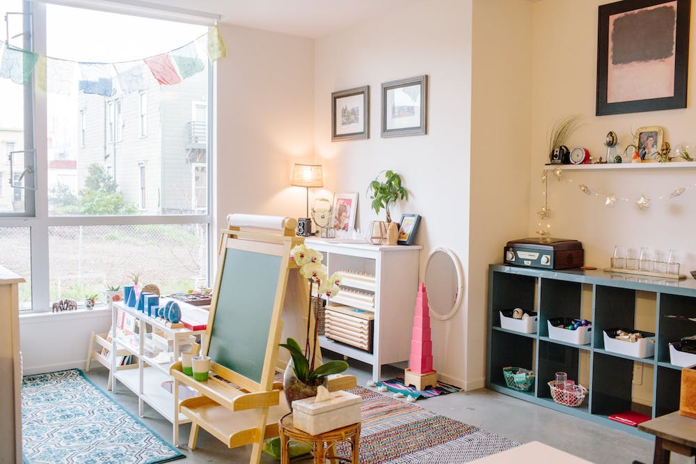 Easel and shelves in a bright room with a large window