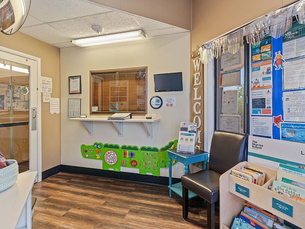 waiting area with a welcome sign, children's toys, and books