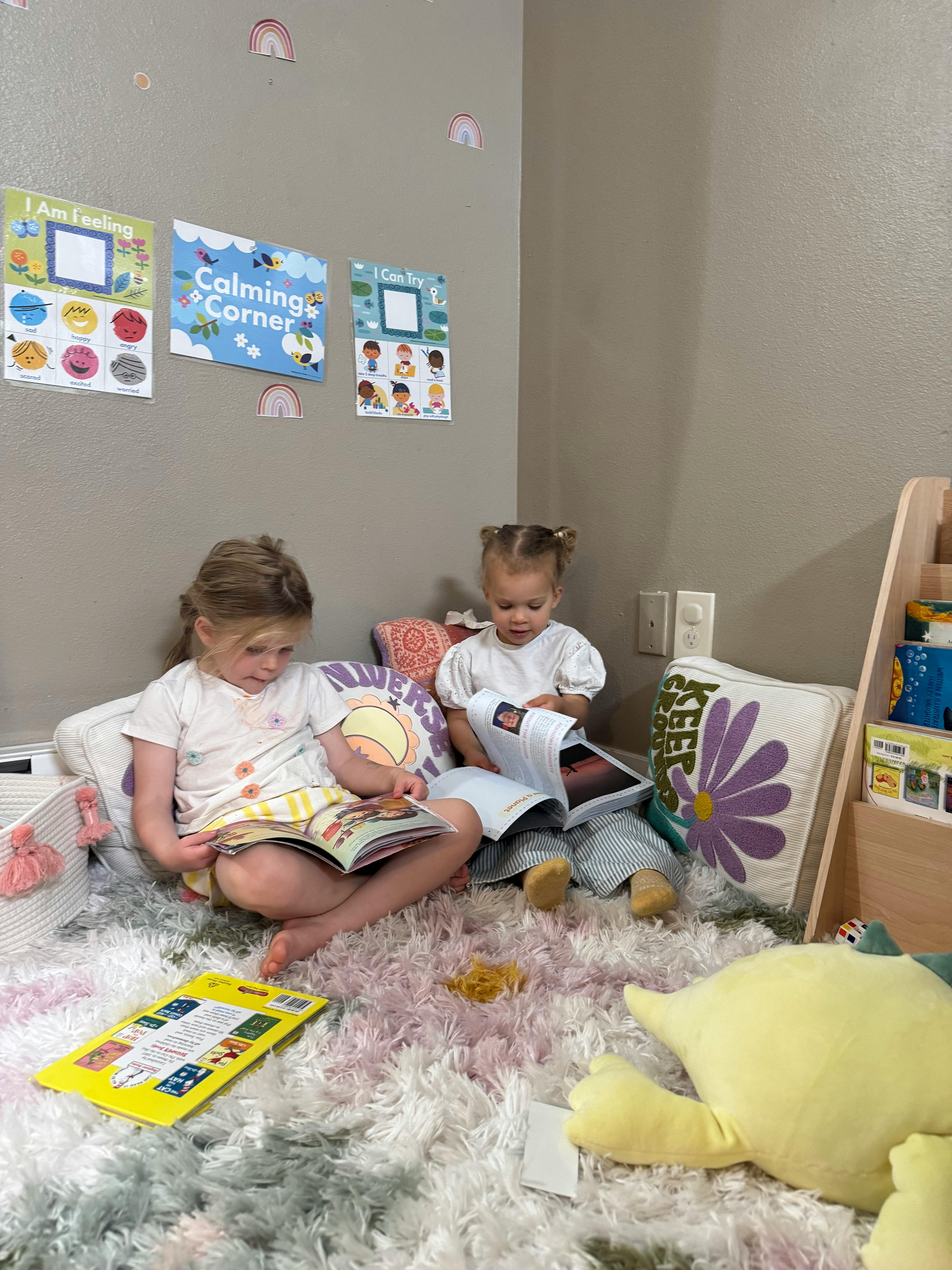 Two children sitting on a rug reading books