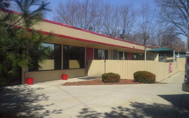 Building exterior with large windows and a tan fence