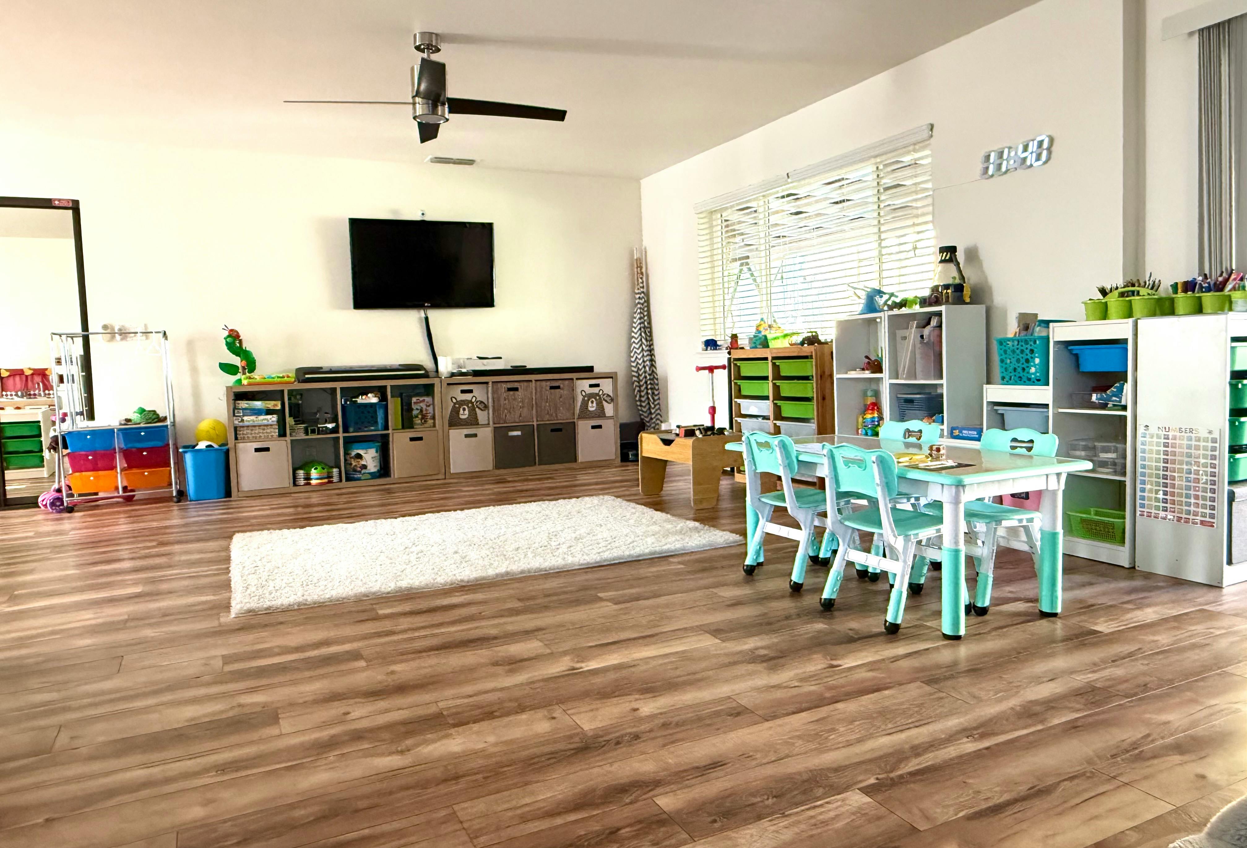 Playroom with small tables and chairs, storage units, and a television