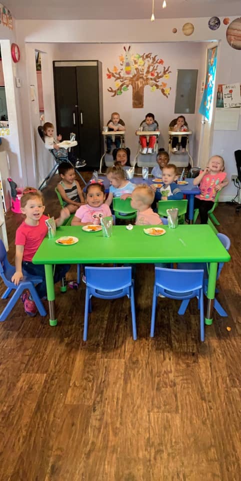 Children sitting at tables in a classroom