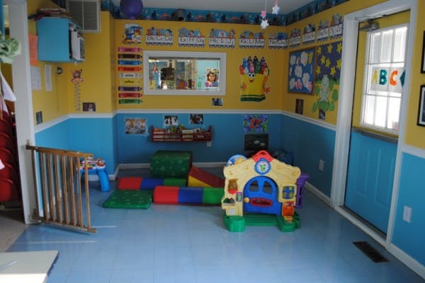 Playroom with soft play equipment and a small playhouse