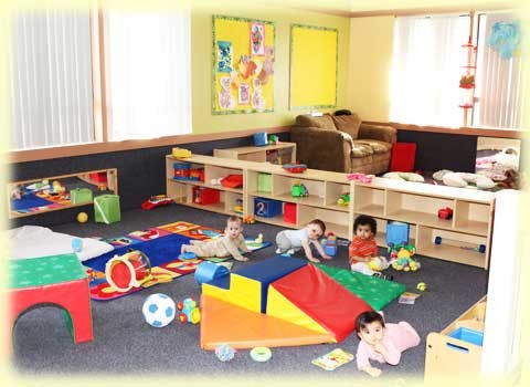 Multiple children playing on the floor in a room with shelves and toys