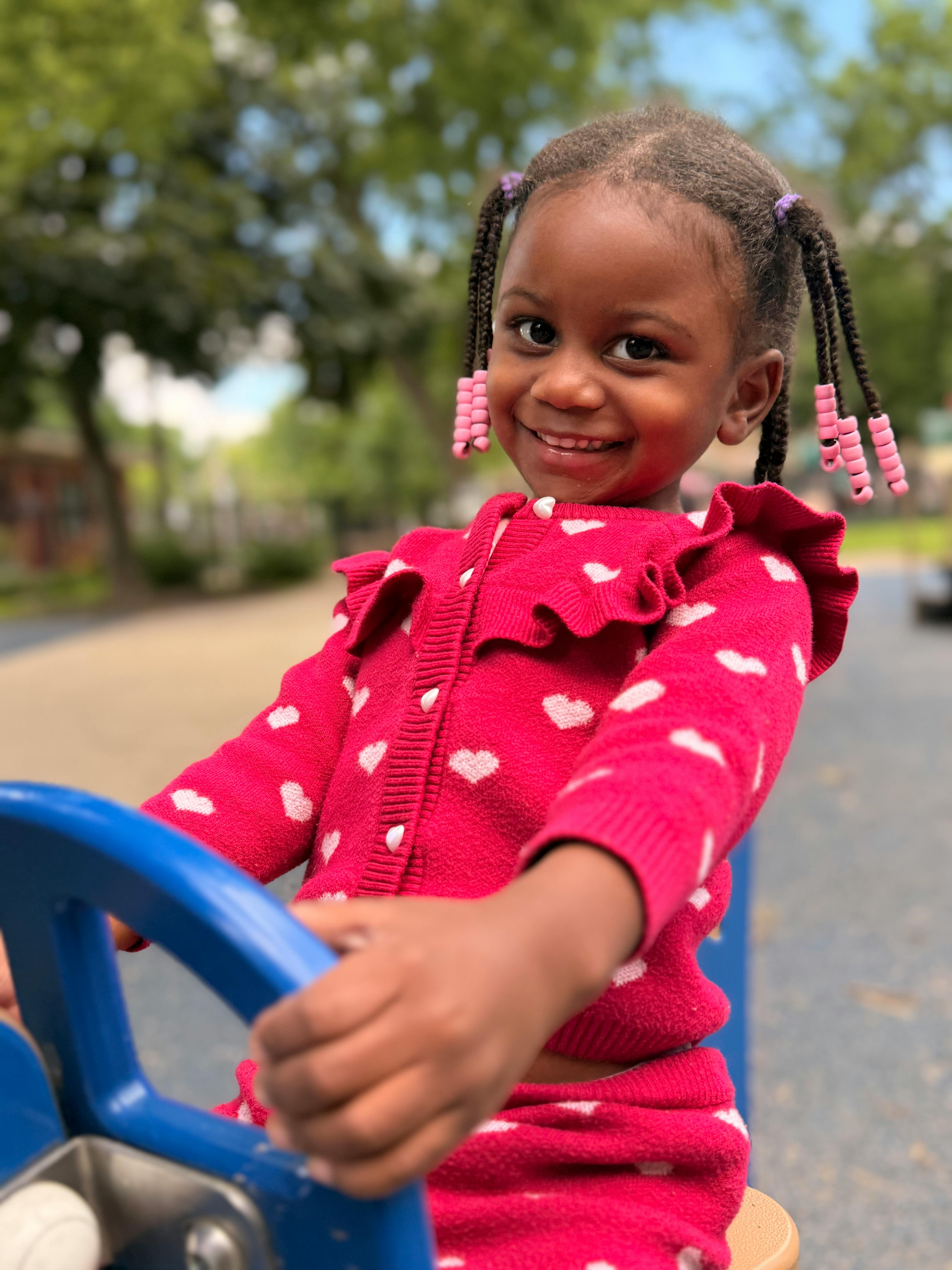 Child playing on a playground equipment with a steering wheel