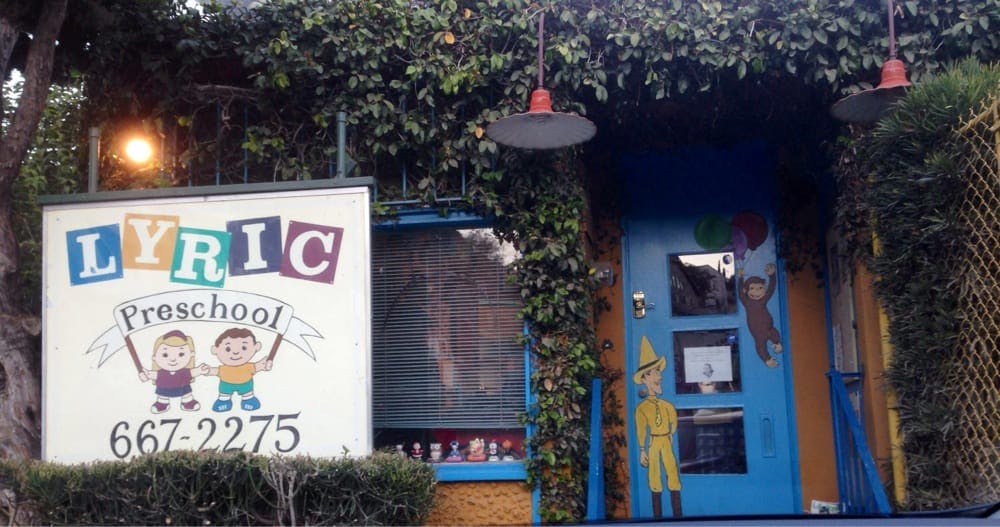 Lyric Preschool sign with two children holding a banner